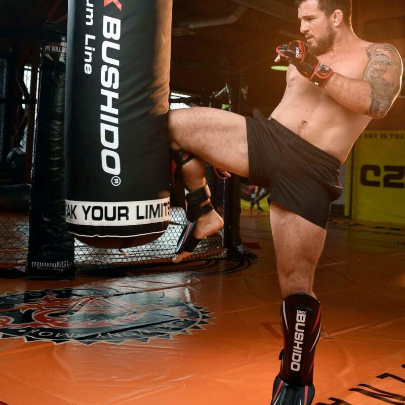 Trening na worku bokserskim w ochraniaczach na piszczele